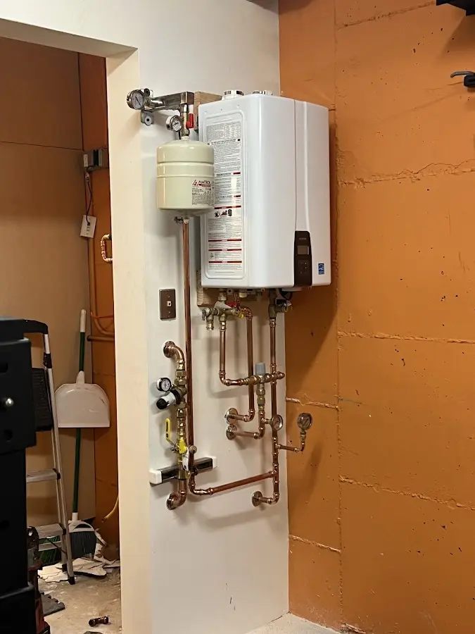 Plumbing technician inspecting water heater connections in North Reading